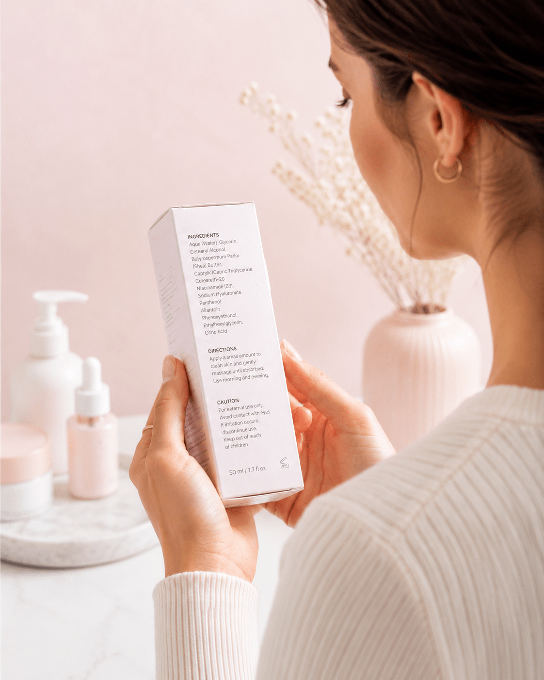 Consumer carefully reading the ingredient list, directions, and warnings on cosmetic packaging